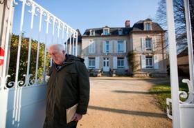 Жан Ванье у ворот своего дома в Троли. Троли - это не специализированное поселение, а обычная деревня на севере Франции. В ней живут 2200 жителей. 10% из них - умственно отсталые, 7% - те, кто им помогает, а остальные 83% - самые обычные люди.